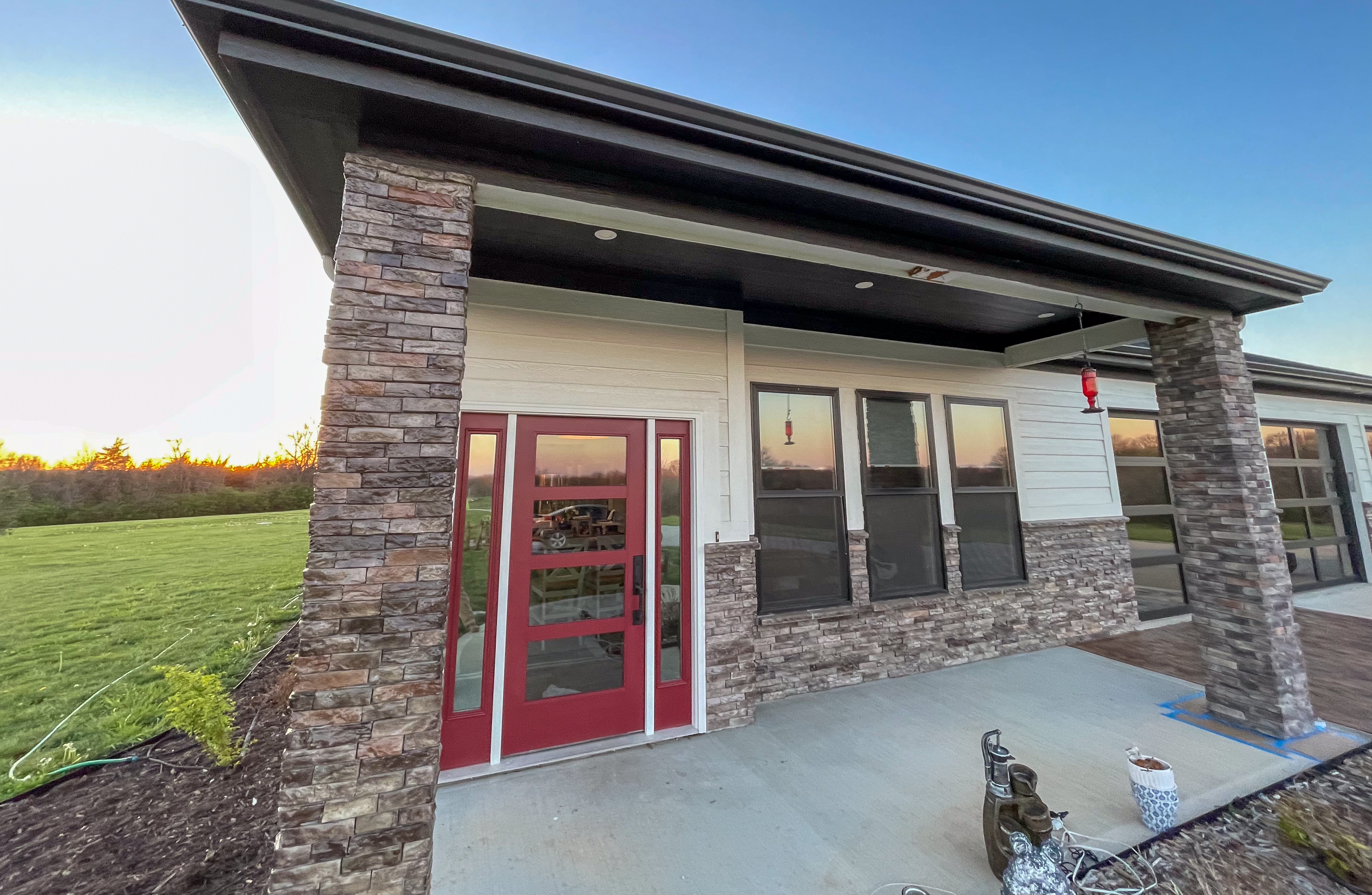 Modern house exterior with bold red front entrance door in Grain Valley, MO by Red Letter Painting