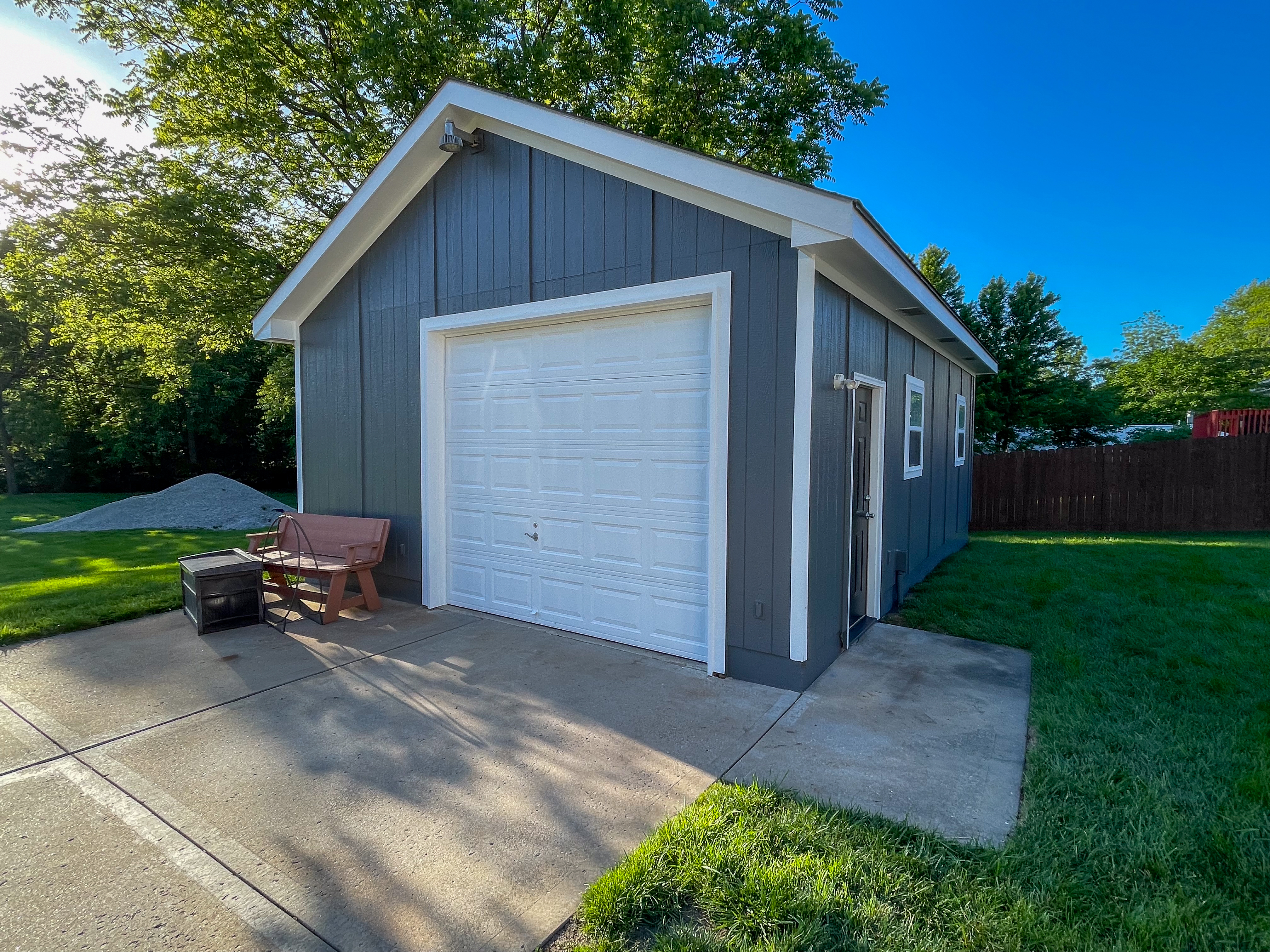 Dark gray detached garage with clean white trim in Grandview, MO by Red Letter Painting