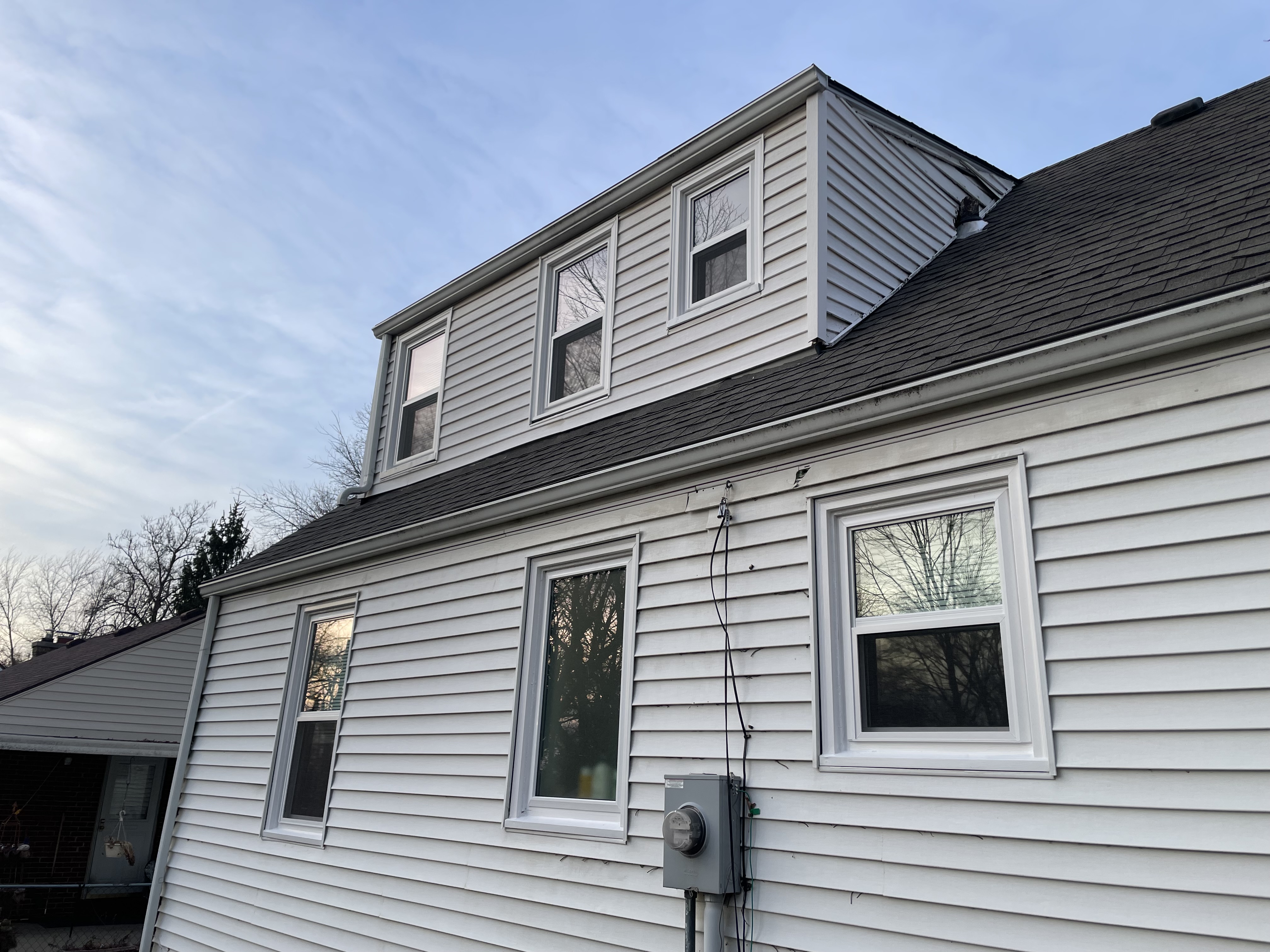 Dormer window trim and siding painting in Independence, MO by Red Letter Painting